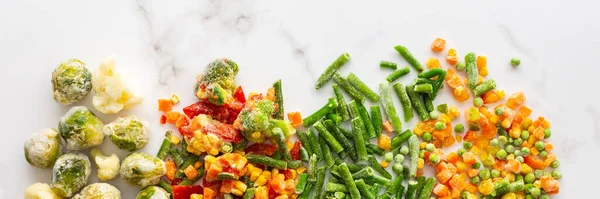 Frozen vegetable mix banner, frozen green beans and broccoli, corn and carrots, brussels sprouts and cauliflower, peas and bell peppers, copy space, top view