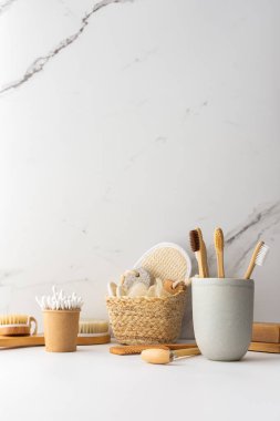 Seramik bardakta doğal tüyleri olan tahta diş fırçaları, yüz ve cilt bakım ürünleri, banyo aksesuarları, spa ve güzellik konsepti.