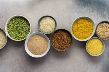 Hafif arka planda, kaselerde çeşitli tahıl gevrekleri, üst manzara