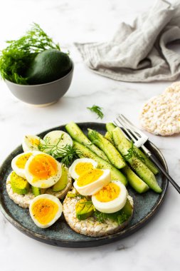Healthy breakfasts, rice cakes with avocado and boiled eggs with dill and cucumber with spices, healthy wholesome food