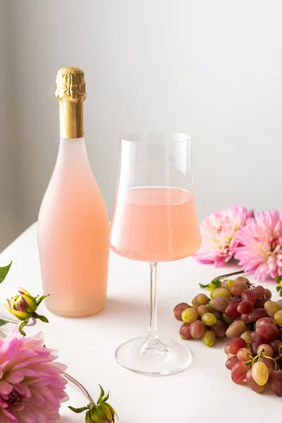 Bicchiere Con Spumante Rosato Una Bottiglia Vino Tavolo Bianco Circondato — Foto Stock