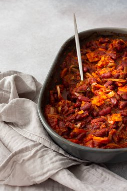 Sağlıklı kahvaltı ve öğle yemekleri, havuçlu kırmızı fasulye, soğan ve domates, oval seramik kızartma makinesi ve güveç.