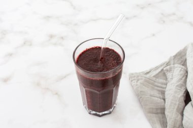 Sağlıklı kahvaltı, donmuş yaban mersini, avokado ve muz püresi, bezelye ve keten tohumu, marul ve kereviz, elma, pipetli bir bardak içinde smoothie.
