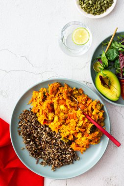 Healthy lunches, wild rice with carrot and tomato gravy, broccoli and onion, fresh mixed salad with pumpkin seeds, water with lemon, top view