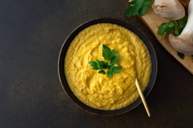 Tabakta mantar kremalı çorba, lezzetli sağlıklı Eringi mantar çorbası, kesme tahtasındaki taze mantarlar, üst manzara.