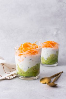 Sağlıklı kahvaltı ve öğle yemekleri, avokado ve yoğurt yanında chia, rendelenmiş havuç ve cam bardaklarda turp.