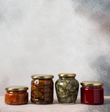 Preserving vegetables for the winter, canned vegetables in jars on a light background, pickled or fermented vegetables, copy space