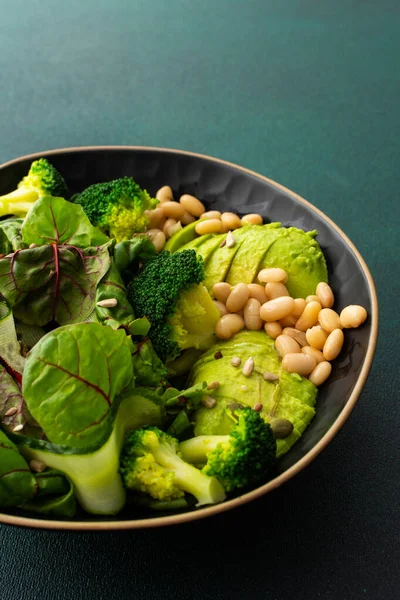 健康的な朝食 豆とキュウリのチャードサラダ アボカドとブロッコリーは異なる種を振りかけ 緑の背景に食べ物のプレート — ストック写真