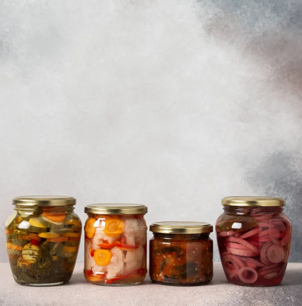 Preserving vegetables for the winter, canned vegetables in jars on a light background, pickled or fermented vegetables, copy space