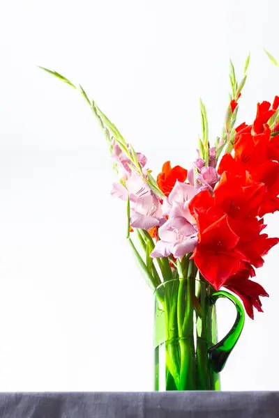 Summer bouquet of red and violet gladiolus, home decoration with flowers, bouquet with flowers on the table