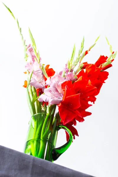 Summer bouquet of red and violet gladiolus, home decoration with flowers, bouquet with flowers on the table