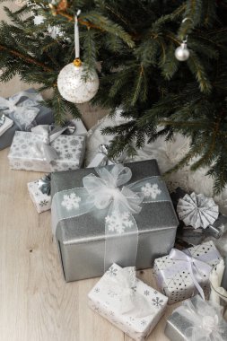 White and silver gift boxes with bows under the Christmas tree, Merry Christmas and Happy New Year