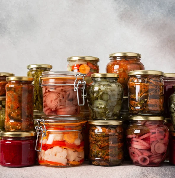 Preserving vegetables for the winter, canned vegetables in jars on a light background, pickled or fermented vegetables, copy space