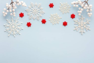 Mavi arka planda beyaz ve kırmızı kar taneleri ve rowan dalları, Noel arkaplanı, Mutlu Noeller ve Mutlu Yıllar konsepti, üst manzara, kopyalama alanı