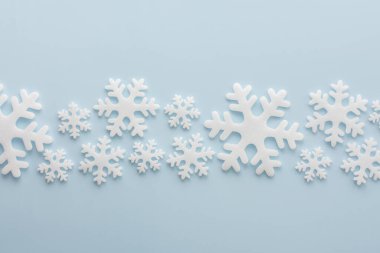 Mavi arka planda beyaz kar taneleri, Noel arkaplanı, Mutlu Noeller ve Mutlu Yıllar konsepti, üst manzara, kopyalama alanı