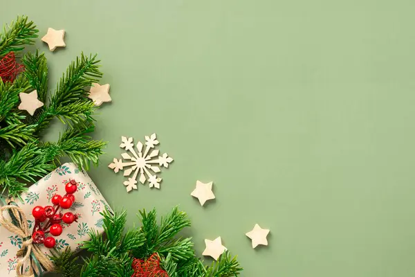 Noel şenliği arka planı, hediye kutuları Rowan dalı ve ahşap yıldızlar ve yeşil arka planda kar tanesi, üst manzara