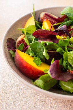 Marullu salata ve incirli şeftali, bej arka planda salata.