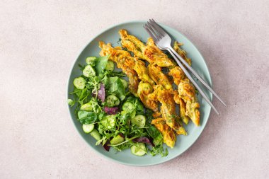 Kızarmış kabak çiçekleri hamurlu ve salatayla salatayı karıştırın.