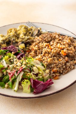 Lezzetli sağlıklı kahvaltı, karabuğday lapası tohumlu salata ve yumurtalı kızarmış mantar.