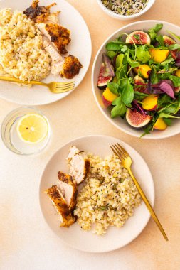 Lezzetli bir öğle yemeği, fırında tavuk göğsü ve tohumlu esmer pirinç incirli salata ve şeftali.
