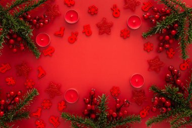Kırmızı Noel arkaplanı köknar dalları ve kırmızı Noel ağacı oyuncakları ve balolar ve mumlar.