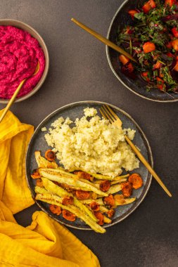 Lezzetli bir vejetaryen yemeği için bol bol darı, fırında kabak ve havuç, mevsimlik sebze ve otlardan oluşan taze bir salata, nohut çörekleri ve pancar humusuyla birlikte sağlıklı bir kahvaltı veya öğle yemeği yiyin.