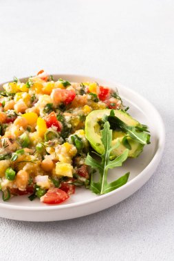 Bu sağlıklı salata kaynamış darı, nohutu, taze sebzeleri ve avokadoyu birleştirir. Hepsi besleyici ve lezzetli bir vejetaryen yemeği için zeytin yağıyla sulanır.