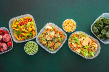 Kışın yiyecek, yazın dondurucu taze sebzeler, arka planda plastik tabaklarda dondurulmuş sebzeler, sebzeli konteynırların arka planı.