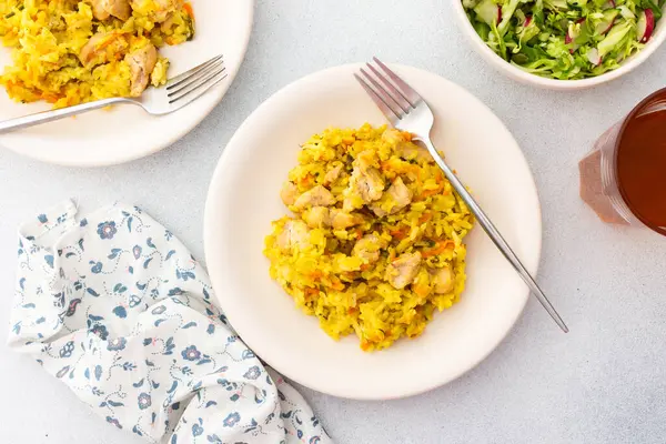 stock image Stewed rice with chicken breast and mixed salad with radishes and various seeds, a served table with food, a delicious hearty lunch or dinner