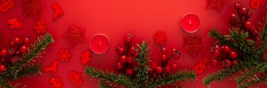 Kırmızı Noel arkaplanı köknar dalları ve kırmızı Noel ağacı oyuncakları ve balolar ve mumlar, afiş