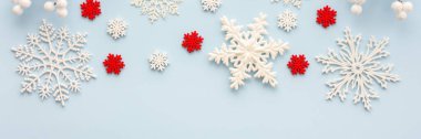Mavi arka planda beyaz ve kırmızı kar taneleri ve rowan dalları, Noel arkaplanı, Mutlu Noeller ve yeni yıl bayrağı, üst manzara, kopyalama alanı