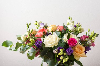 Taze güller ve okaliptüs içeren renkli bir yaz buketi ile özel kutlamalar, güzel ve güzel kokulu bir çiçek aranjmanı oluşturur.