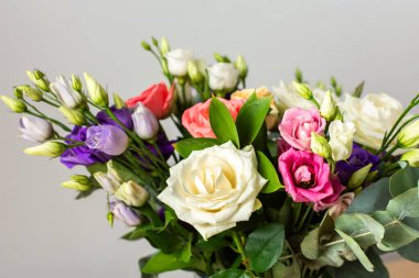 Taze güller ve okaliptüs içeren renkli bir yaz buketi ile özel kutlamalar, güzel ve güzel kokulu bir çiçek aranjmanı oluşturur.