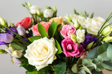 Taze güller ve okaliptüs içeren renkli bir yaz buketi ile özel kutlamalar, güzel ve güzel kokulu bir çiçek aranjmanı oluşturur.