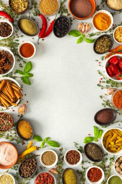 Gri üzerine çeşitli otlar ve baharatlardan oluşan canlı bir çerçeve, yemek pişirme ilhamı için canlı renkleri ve tatları vurguluyor, üst görünüm, kopyalama alanı
