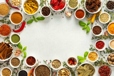 Taze ve renkli baharatlar ve bitkiler gri bir arkaplanda çerçevelenmiş, doğal güzellik ve mutfak cazibesi ekleyerek, üst görünüm, kopyalama alanı