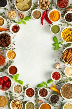 Gri üzerine çeşitli otlar ve baharatlardan oluşan canlı bir çerçeve, yemek pişirme ilhamı için canlı renkleri ve tatları vurguluyor, üst görünüm, kopyalama alanı