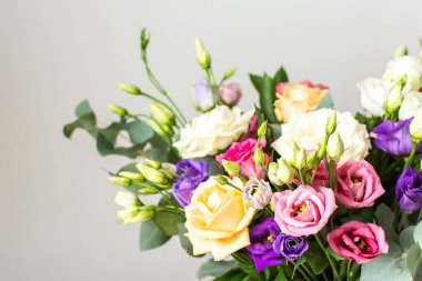 Taze güller ve okaliptüs içeren renkli bir yaz buketi ile özel kutlamalar, güzel ve güzel kokulu bir çiçek aranjmanı oluşturur.