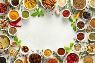 Taze ve renkli baharatlar ve bitkiler gri bir arkaplanda çerçevelenmiş, doğal güzellik ve mutfak cazibesi ekleyerek, üst görünüm, kopyalama alanı