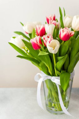 Cam bir vazoda pembe ve beyaz lale buketi, doğum günü veya 8 Mart veya anneler günü konsepti.