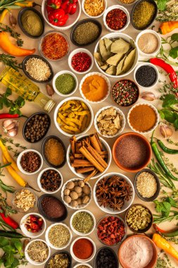 Bej bir arka planda çeşitli baharat ve otlar, zengin kokular ve canlı renkler sunuyor, herhangi bir mutfak yaratımına sıcaklık katmak için ideal.