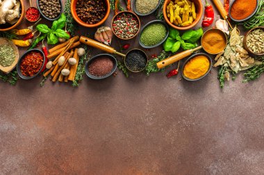 Canlı, taze kokulu baharat ve bitkilerden oluşan bir koleksiyon. Kahverengi bir arka planda renkli bir şekilde sergileniyor. Doğal ve aromatik güzelliklerini sergiliyorlar.