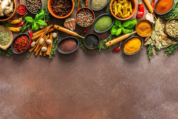 Canlı, taze kokulu baharat ve bitkilerden oluşan bir koleksiyon. Kahverengi bir arka planda renkli bir şekilde sergileniyor. Doğal ve aromatik güzelliklerini sergiliyorlar.