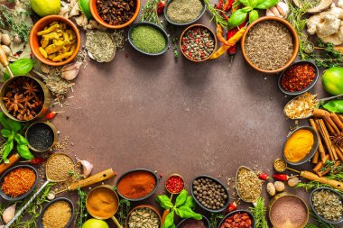 Değişik baharat ve otlardan oluşan bir koleksiyon. Kahverengi bir arka fonda zarif bir şekilde yerleştirilmiş. Doğal güzellik yayıyor.