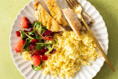 Darı, yağsız tavuk göğsü, greyfurtlu narenciye salatası besleyici bir başlangıç için protein, lif ve vitaminleri birleştiren sağlıklı bir kahvaltı tabağı.