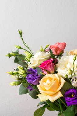 Güzel bir buket canlı gül, okaliptüs, ve beyaz, pembe ve mor renkte narin bir östoma, yıldönümü veya doğum günü kutlaması için mükemmel.