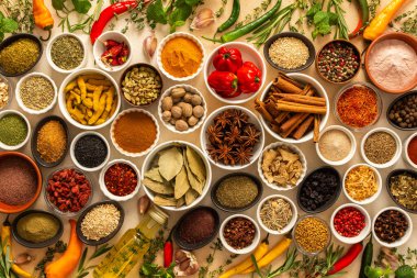 Bej arka planda çeşitli yemek pişirme baharatları ve kurutulmuş otlar var. Mutfak deneyimlerini geliştiren doğal dokular sergileniyor.