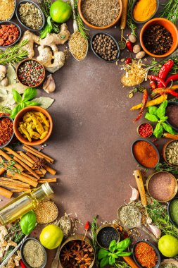 Sıcak kahverengi bir arka planda çeşitli kokulu bitkiler ve baharatlar, görsel çeşitliliklerini gösteren aromatik cazibe, baharat çerçevesi