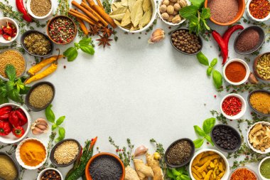 Taze ve renkli baharatlar ve bitkiler gri bir arkaplanda çerçevelenmiş, doğal güzellik ve mutfak cazibesi ekleyerek, üst görünüm, kopyalama alanı