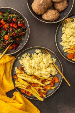Lezzetli bir vejetaryen yemeği için bol bol darı, fırında kabak ve havuç, mevsimlik sebze ve otlardan oluşan taze bir salata, nohut çörekleri ve pancar humusuyla birlikte sağlıklı bir kahvaltı veya öğle yemeği yiyin.